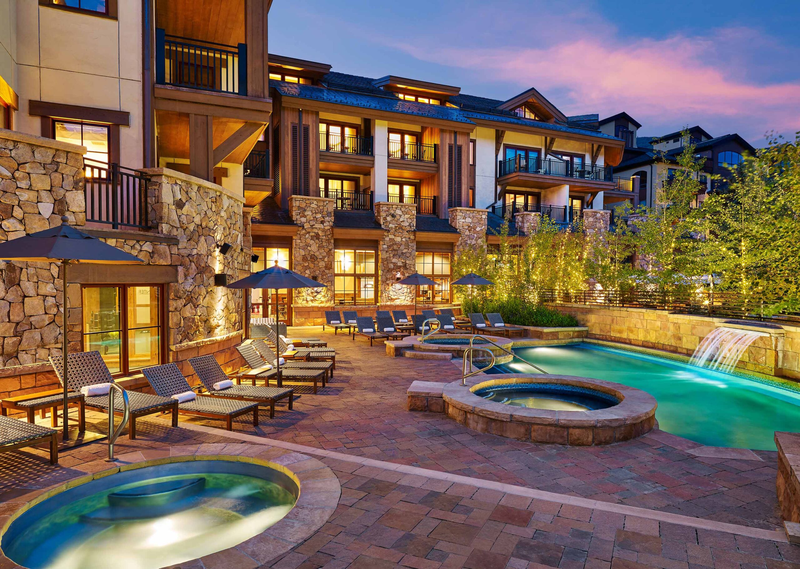 The pool area lit up in the evening at The Sebastian - Vail